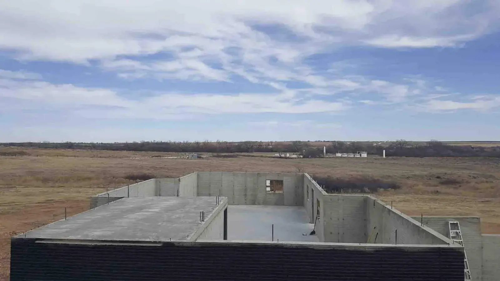 A large poured-concrete basement under a wide Oklahoma sky