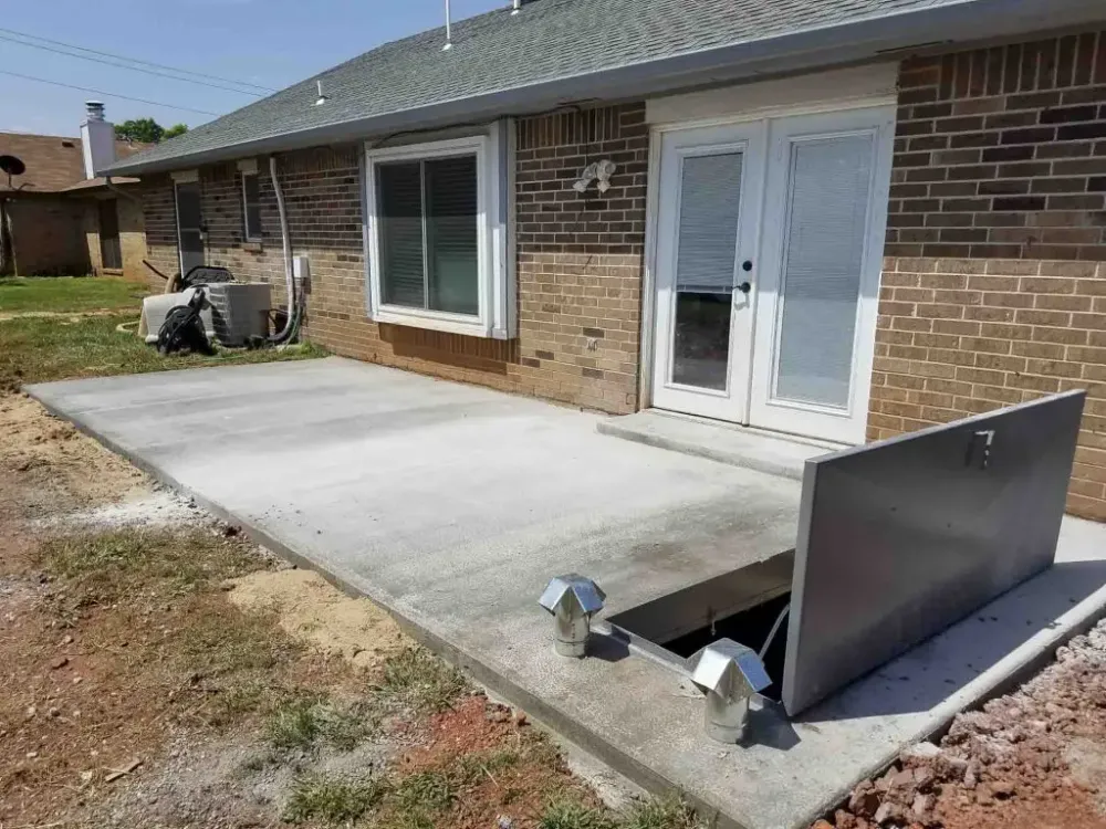 Patio Top shelter door poured into a concrete patio slab beside a brick home