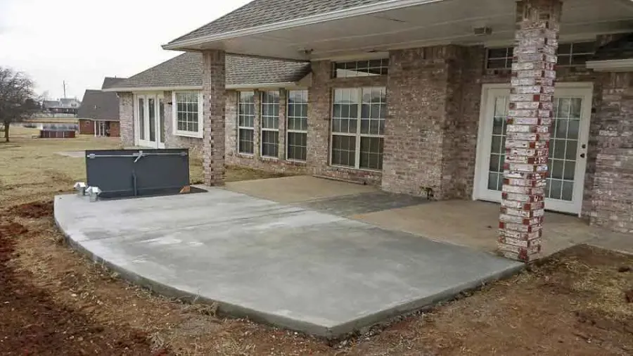 Curved patio slab with a shelter door beside brick columns